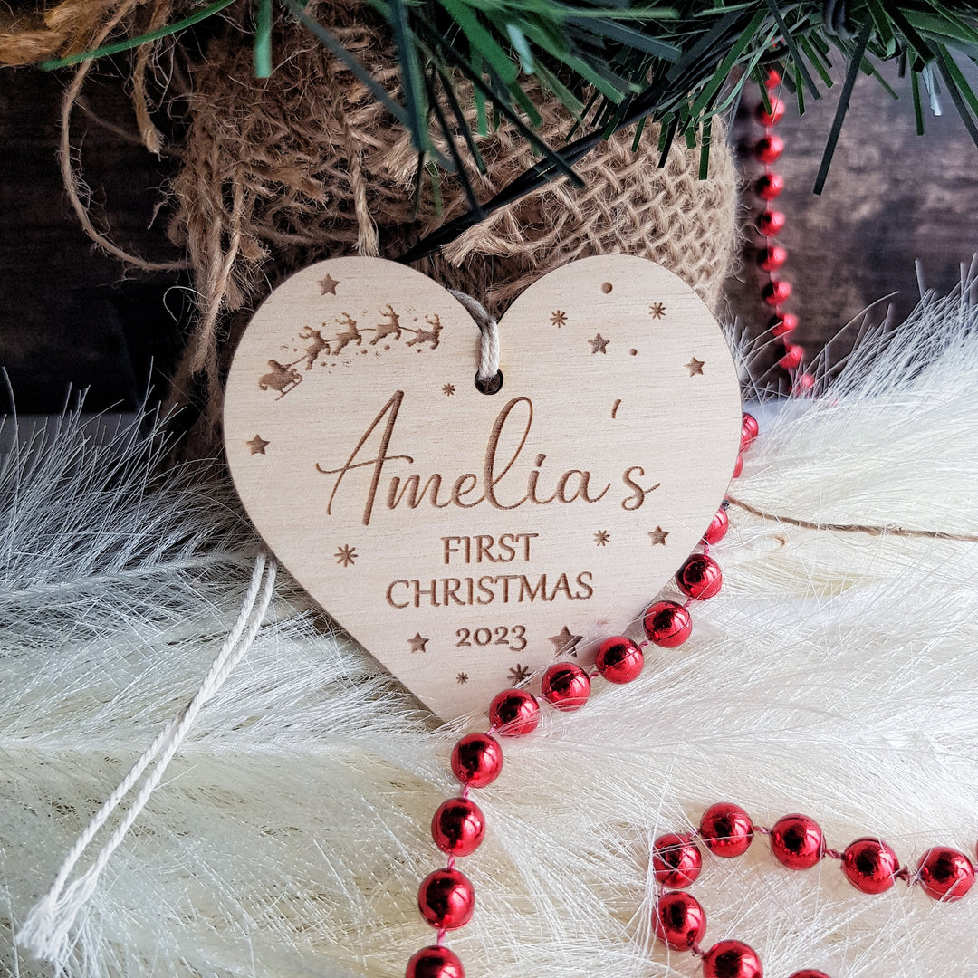 a wooden heart ornament hanging from a christmas tree