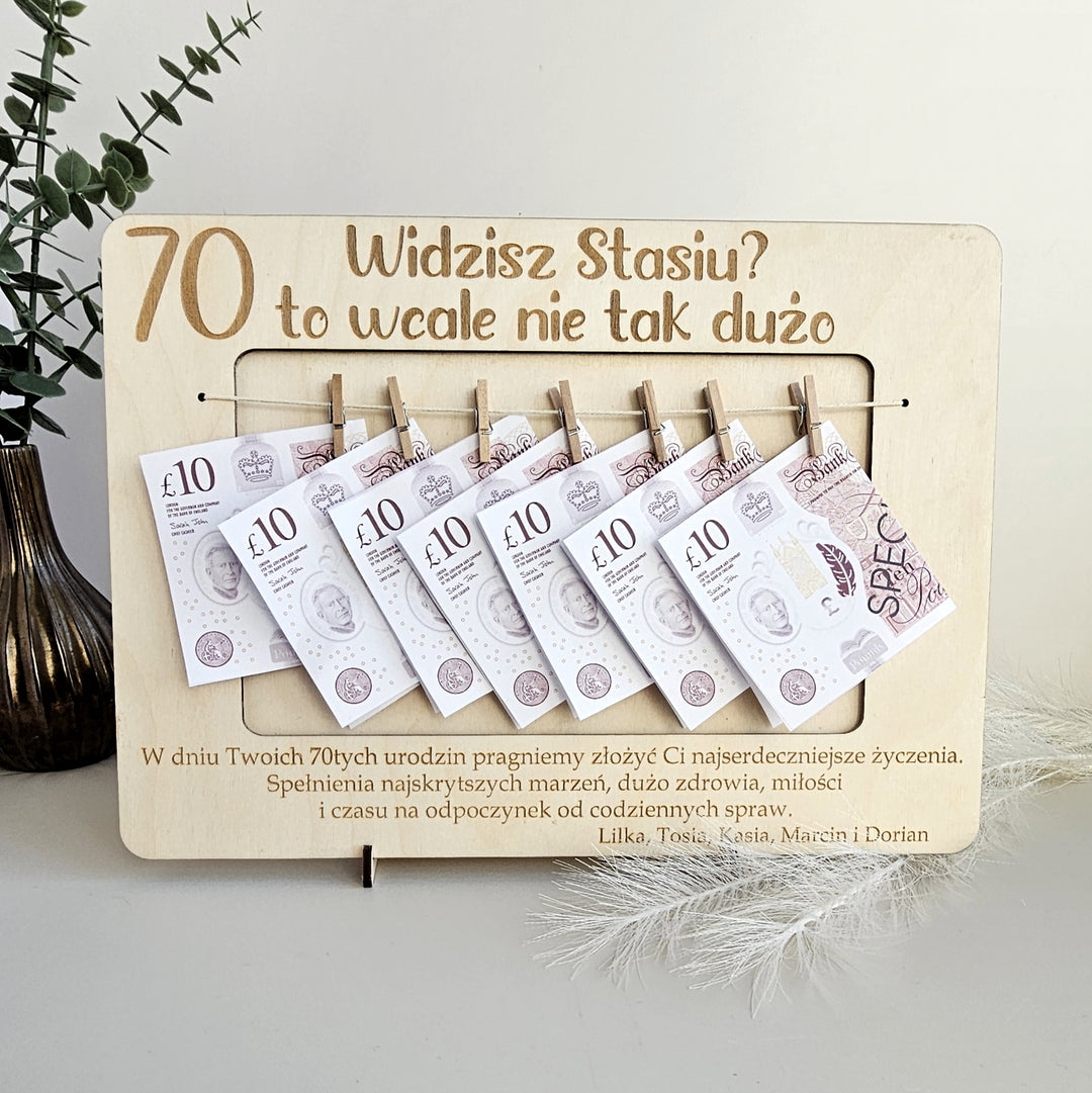 A wooden frame with a series of Polish ten-pound banknotes hanging from it, along with a message in Polish asking "Widzisz Stasiu? to wale nie tak duzo".