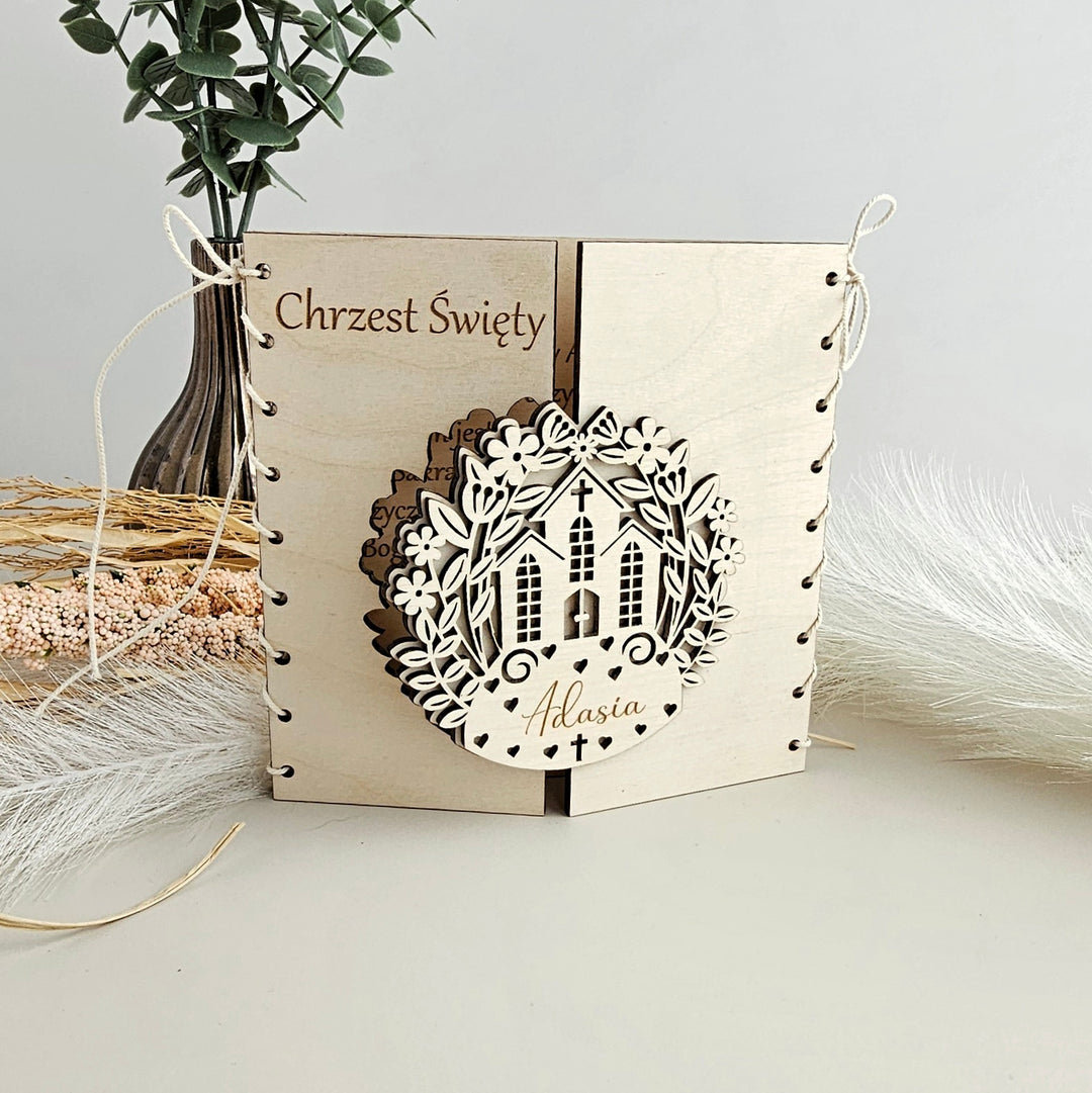 A wooden card with a decorative border and a nameplate, placed on a white surface.