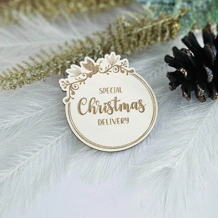 A white wooden Christmas card with the text "SPECIAL CHRISTMAS DELIVERY" is displayed on a white background, surrounded by decorative elements such as feathers and a pine cone.