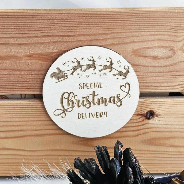 A round wooden coaster with the text "SPECIAL Christmas DELIVERY" engraved on it, along with a small illustration of Santa Claus and reindeer.