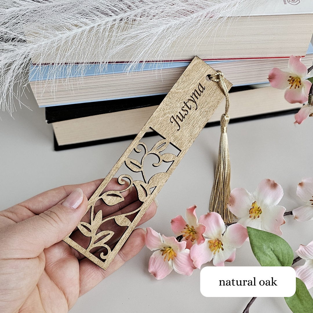 a person holding a bookmark with a feather on it