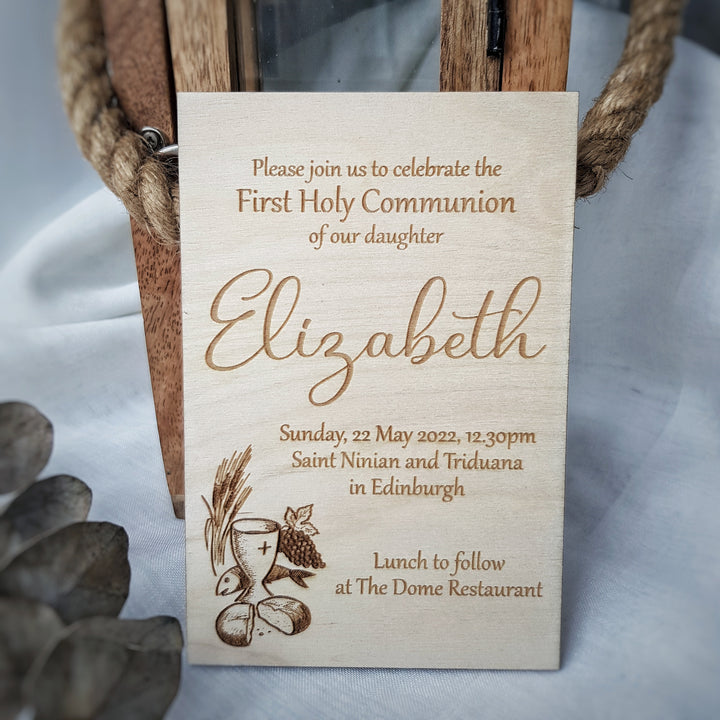 A wooden sign with text inviting people to a First Holy Communion celebration for Elizabeth, with details about the date, time, location, and event at The Dome Restaurant.