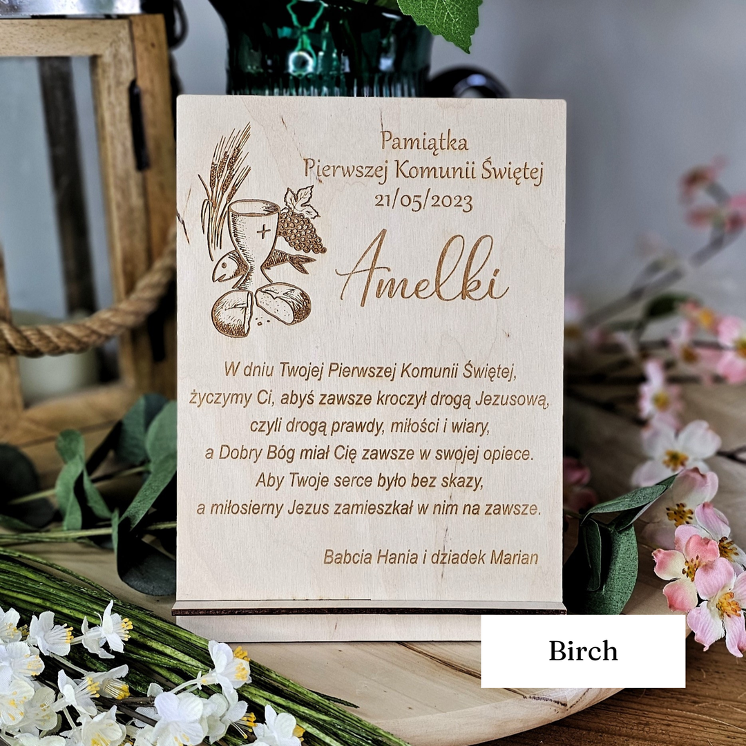 a wooden sign with text and an illustration, placed on a wooden surface surrounded by flowers.