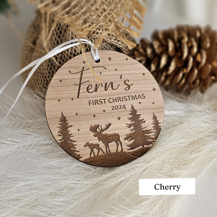 A wooden ornament with a deer silhouette and a starry night sky, along with the text "Fern's FIRST CHRISTMAS 2023" and the word "cherry".