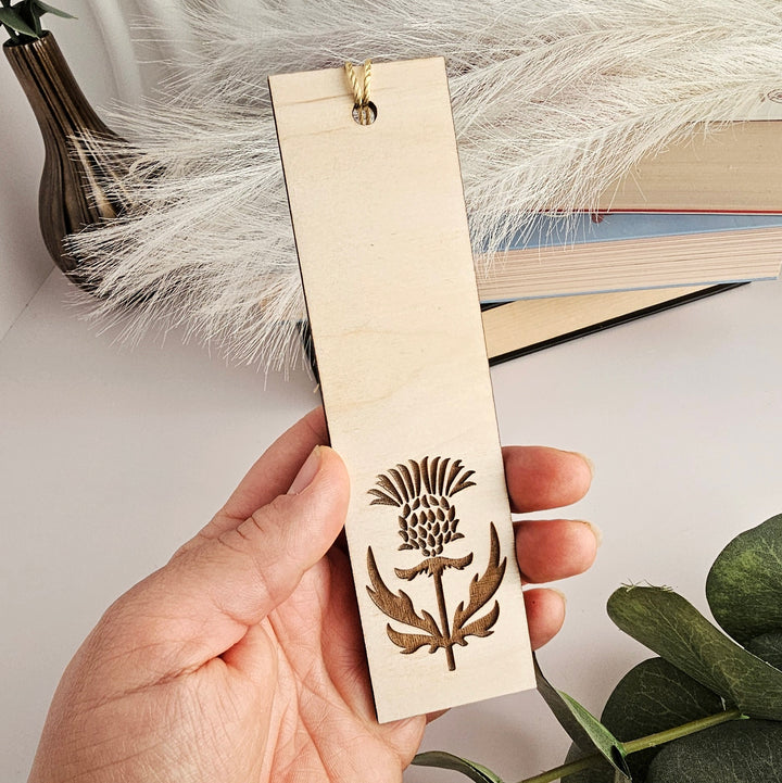 a person holding a bookmark with a flower on it