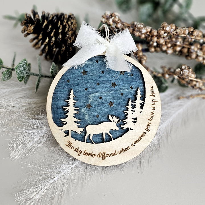 a wooden ornament with a deer in the woods