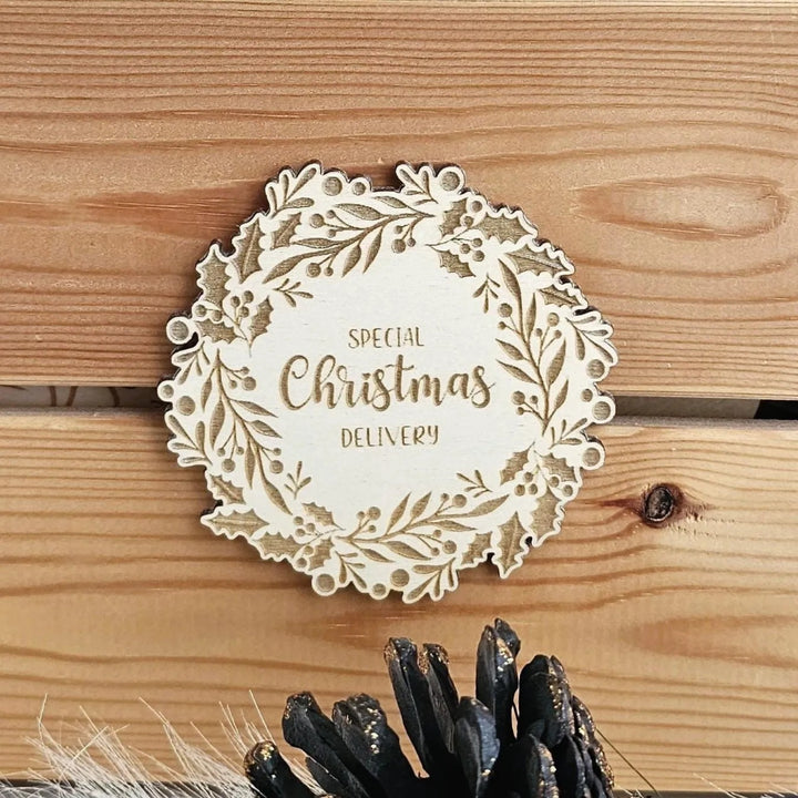 A wooden surface with a decorative wreath-shaped object featuring the text "SPECIAL CHRISTMAS DELIVERY" on it.