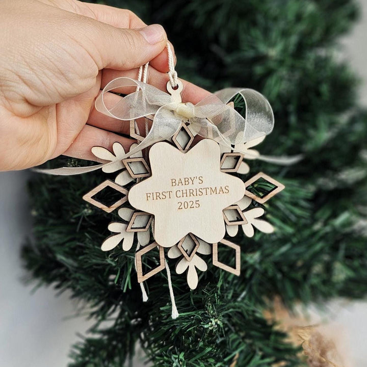 Three-layer wooden snowflake ornament with engraved Baby’s First Christmas 2025 text