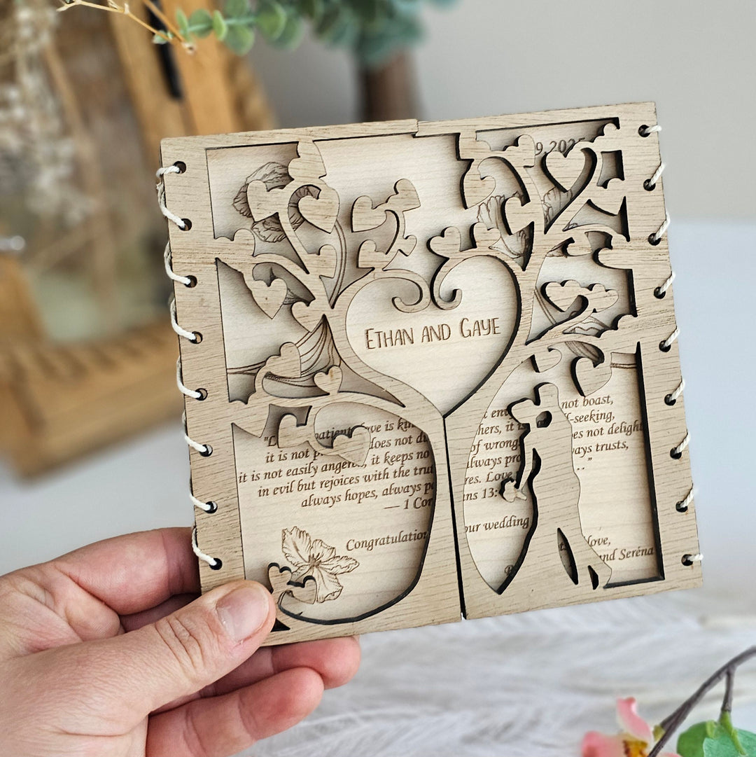 A hand holding a wooden card with intricate cut-out designs, including a tree-like shape and floral elements.