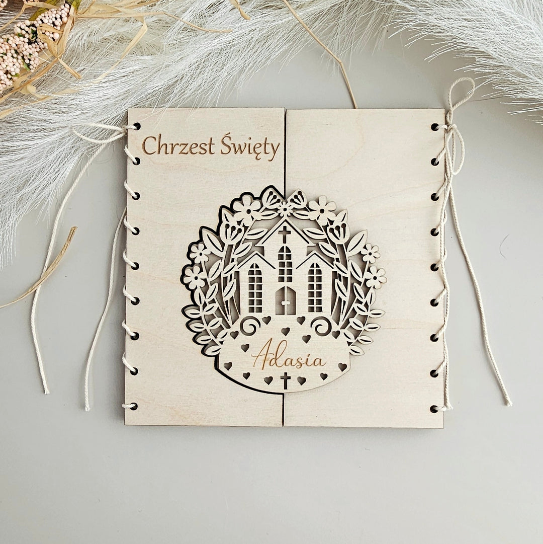 A wooden frame with a decorative cutout of a church and floral elements, along with the name 'Atlasia' written on it.