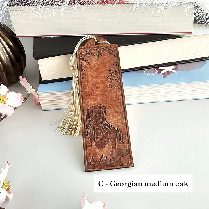 A wooden bookmark with a carved design, placed on top of a stack of books.