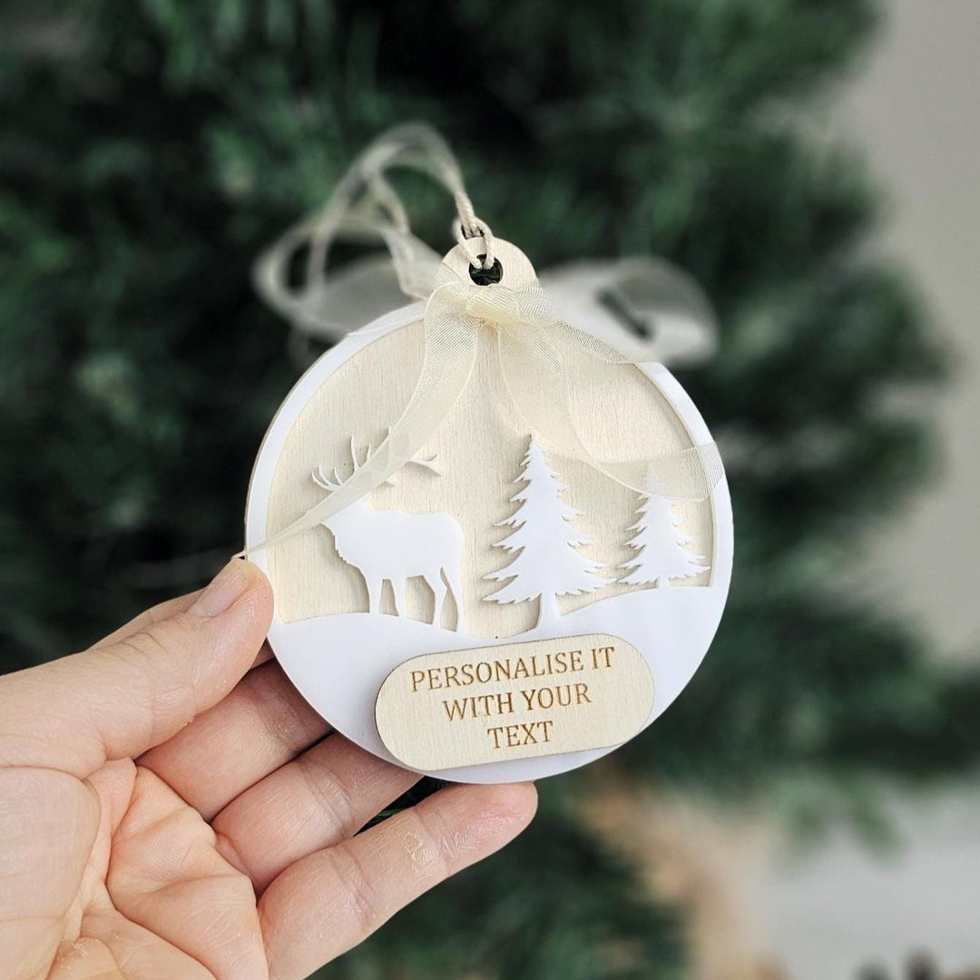 Neutral scandi style Christmas bauble held in hand.