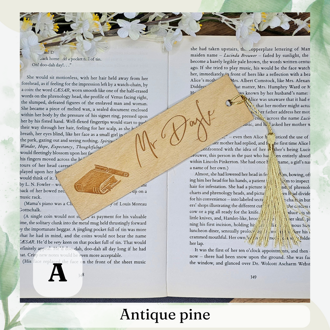 an open book with a wooden bookmark and a tassel