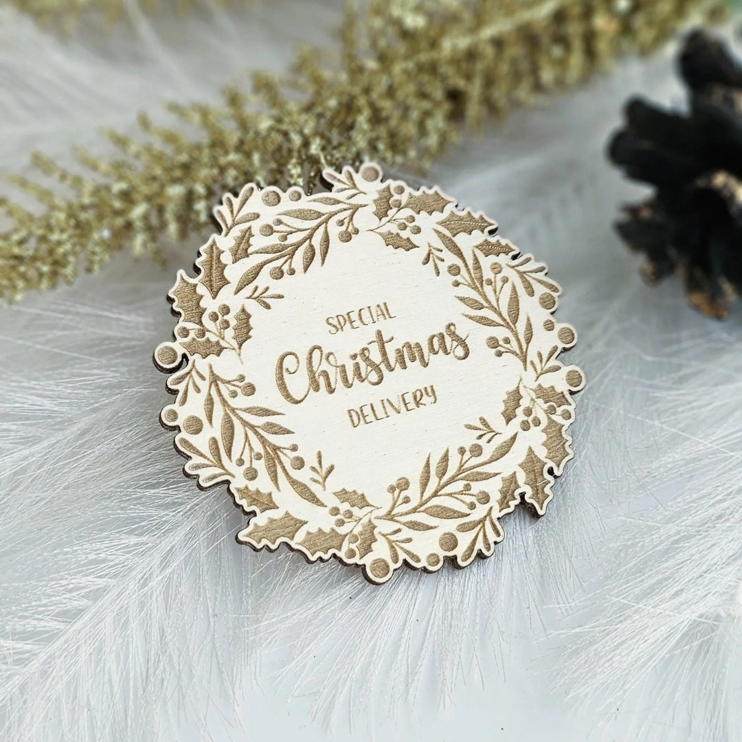 A wooden Christmas-themed label with the text "SPECIAL CHRISTMAS DELIVERY" is displayed on a white background, surrounded by decorative elements such as feathers.