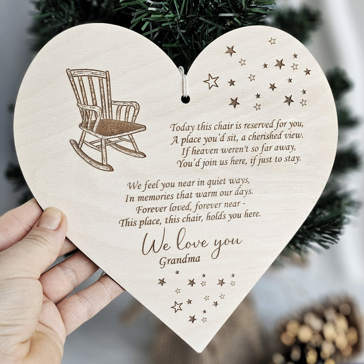 a person holding a wooden heart shaped like a rocking chair