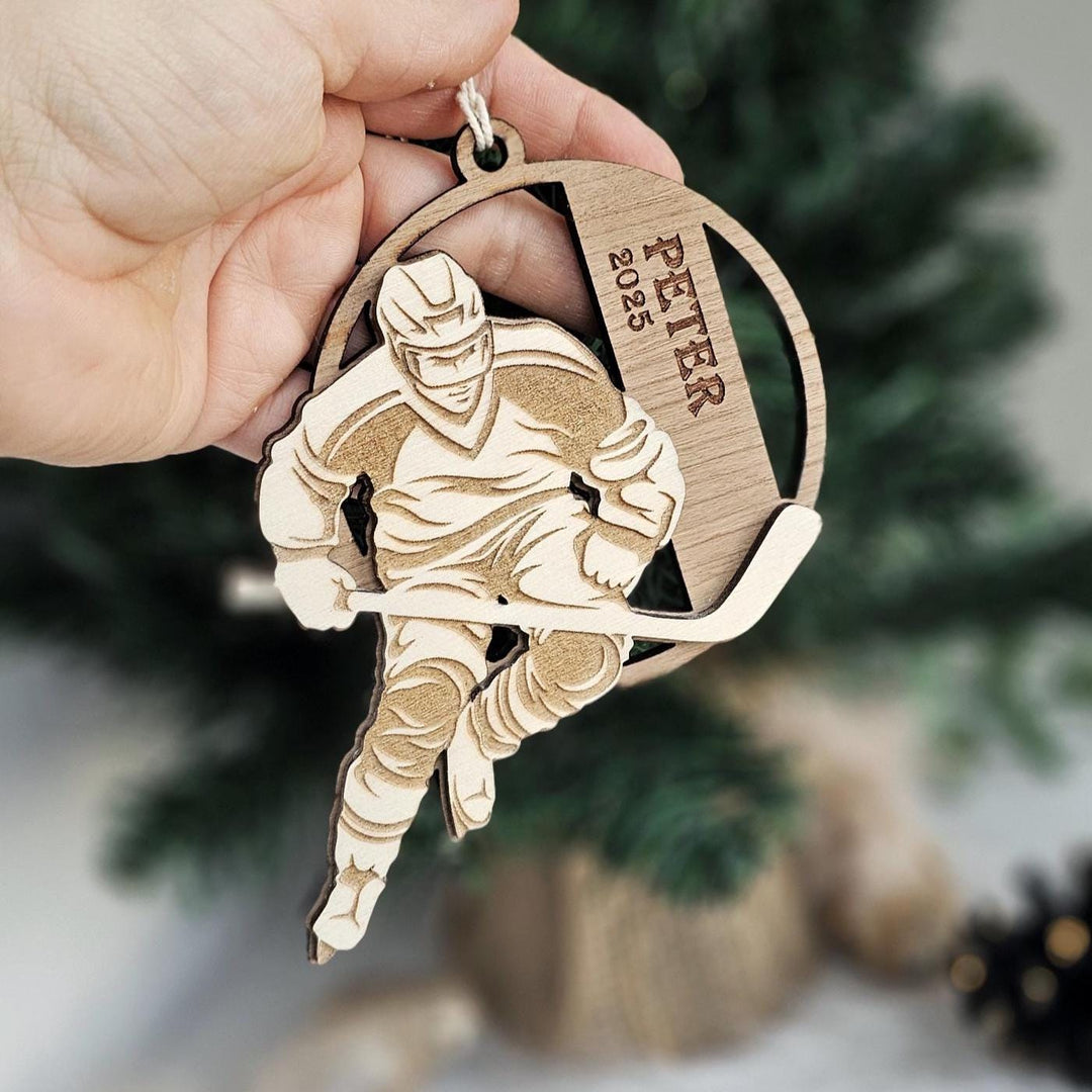 Hand holding personalised wooden hockey Christmas decoration with engraved text