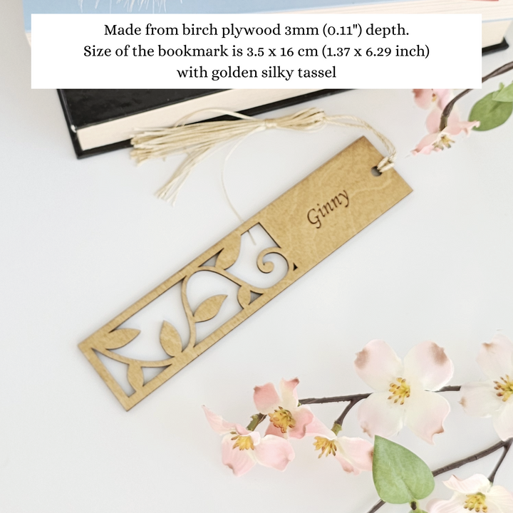 a bookmark with a name on it next to some flowers