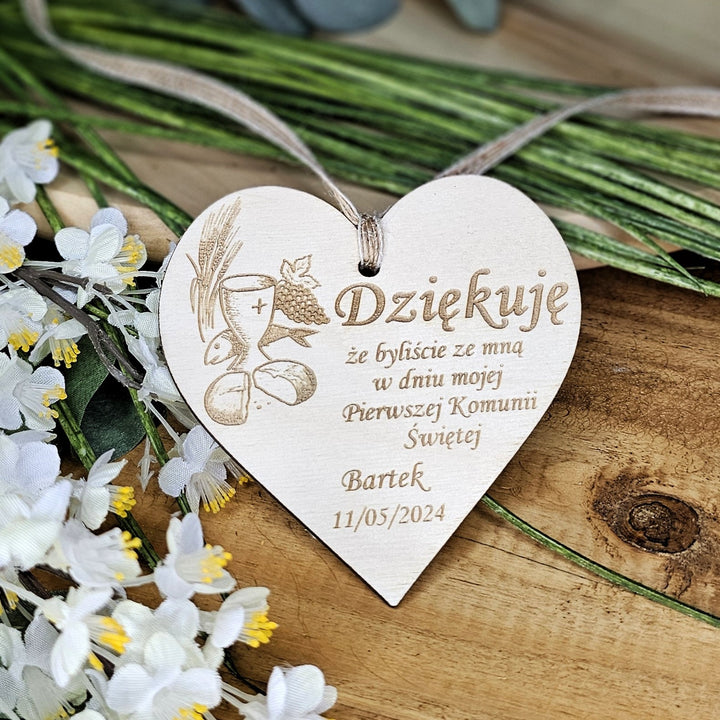 a wooden heart shaped ornament on a table with flowers