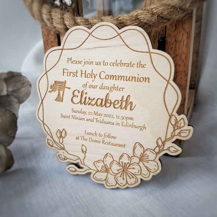 A wooden sign with a floral design and text inviting people to a First Holy Communion celebration of Elizabeth.