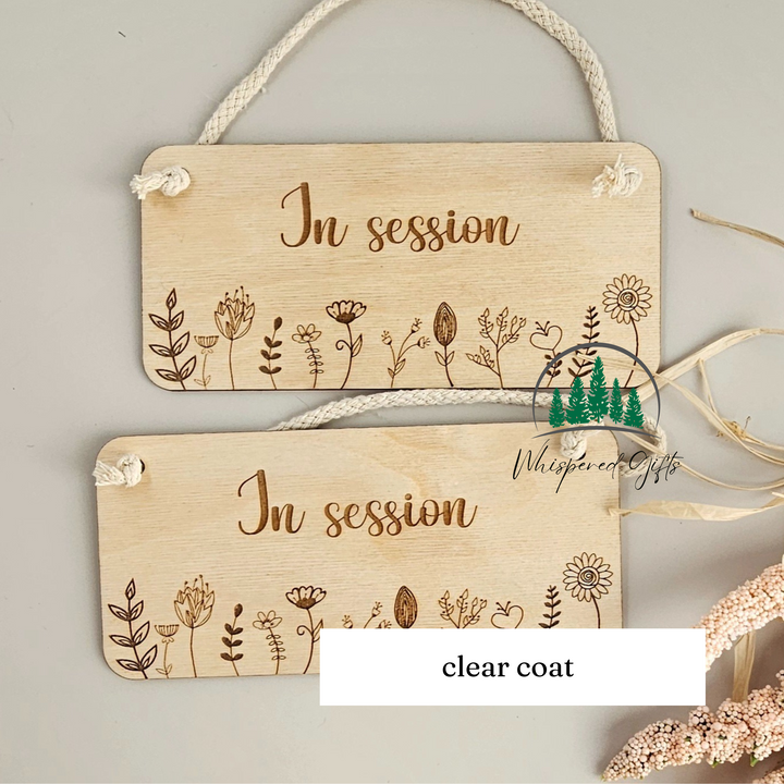 two wooden signs with the text "In session" engraved on them, hanging on a rope.