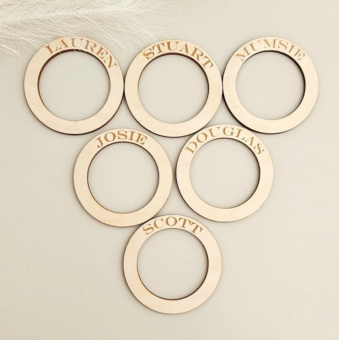 six wooden rings with names on them