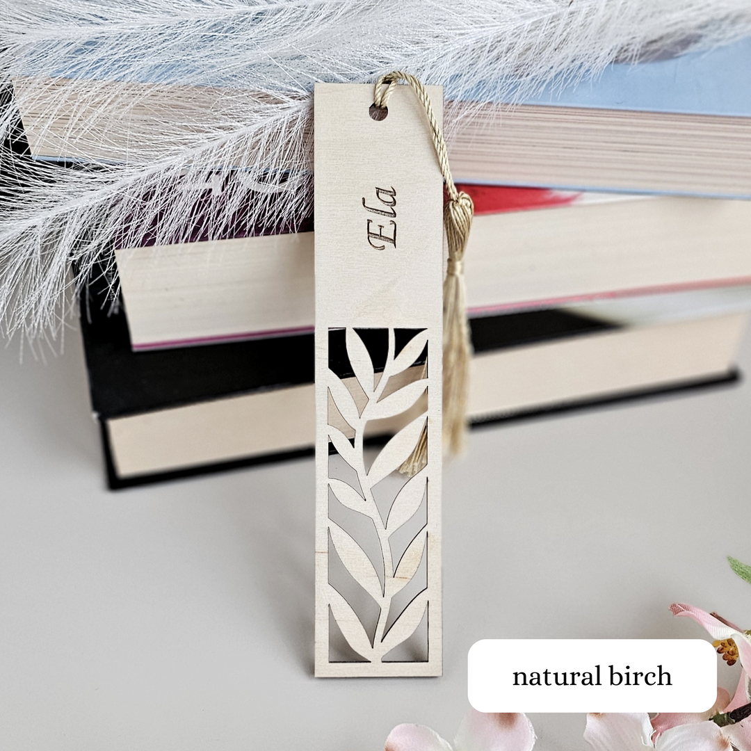 a bookmark with a name on it next to a pile of books