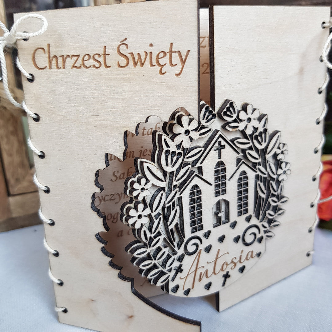 a wooden card with a decorative floral design and the name 'Antosia' written on it.