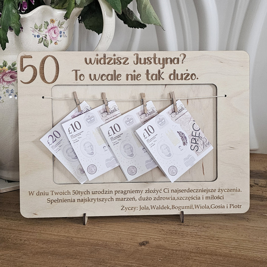 A wooden frame with a collection of banknotes attached to it, along with a message in Polish.