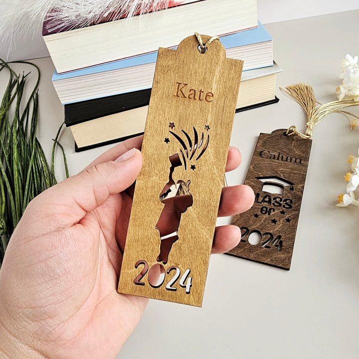 a person holding a wooden bookmark with a picture on it