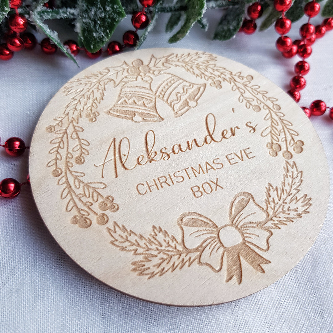 a wooden christmas ornament with a wreath and bells